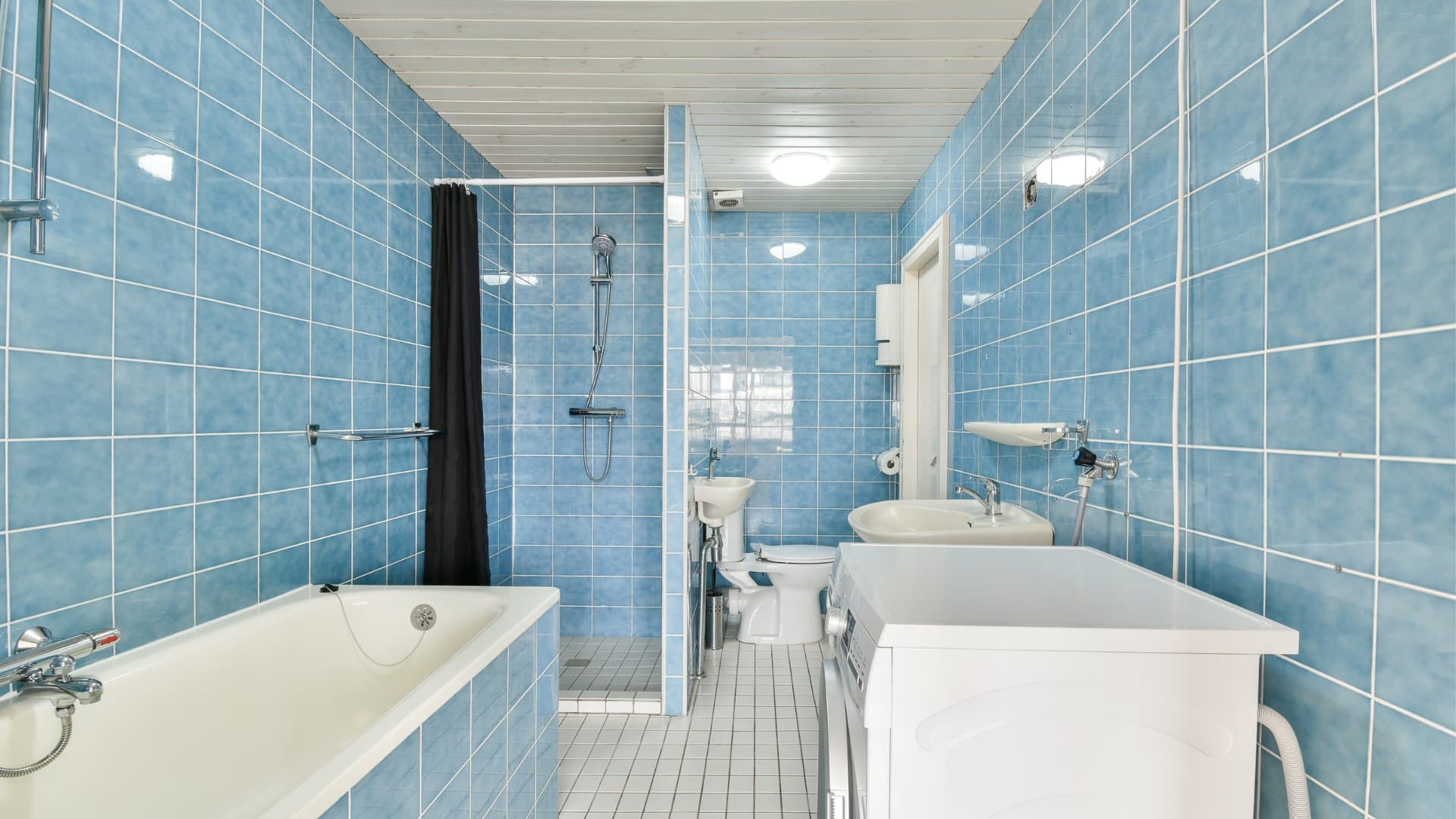 Typical Albany bathroom before remodel with outdated blue tile
